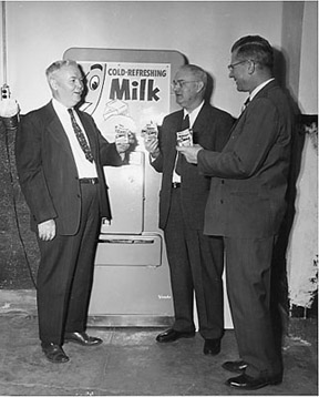 Dean John H. Longwell, an unidentified man, and Loren A. Gafke pose with milk from the Department of Dairy Science's creamery in 1955.